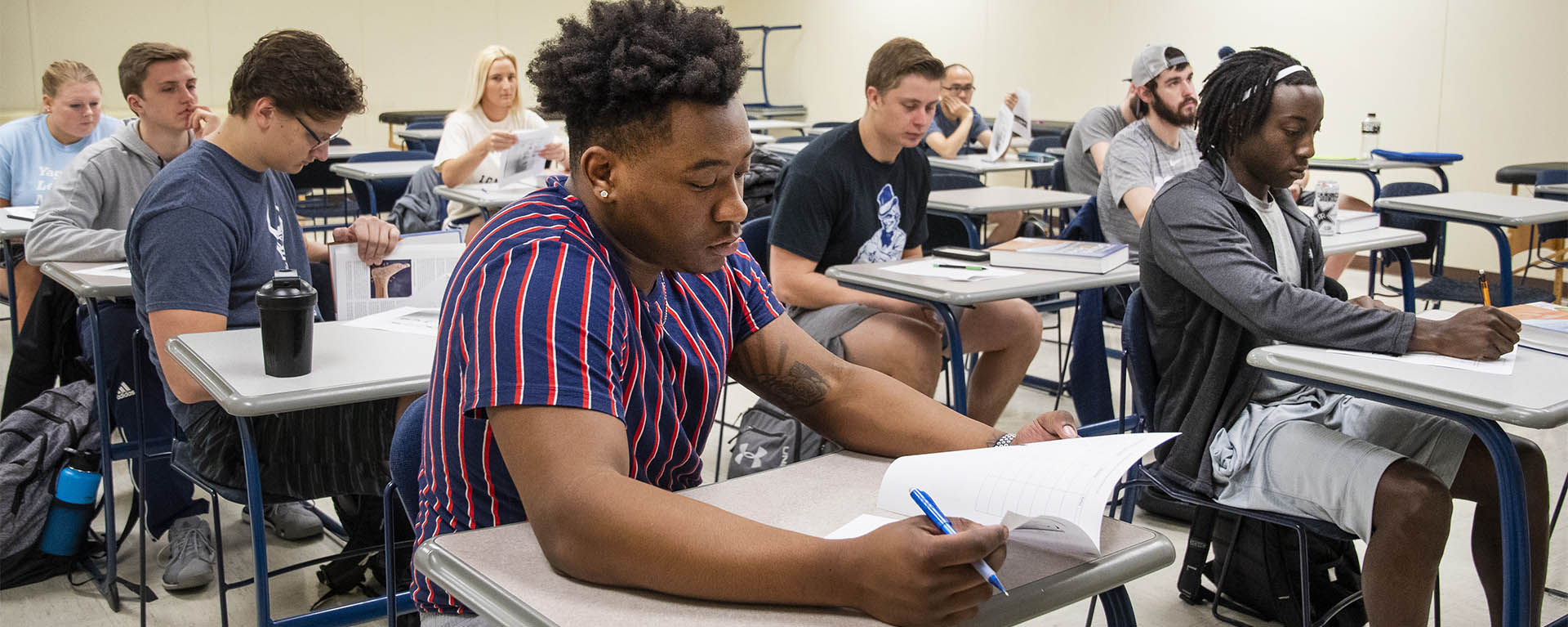 Students look at their books while in a Kinesiology class.